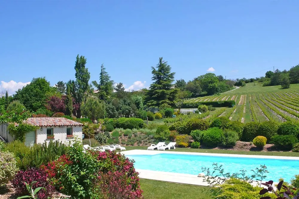Photographie d'une piscine et des vignobles de l'AOC Clairette de Die