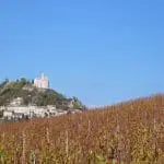 Photographie d'un village perché et de vignobles dans la Drôme