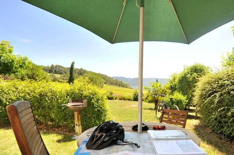 Photographie d'un jardin avec un vélo, un casque et une carte IGN