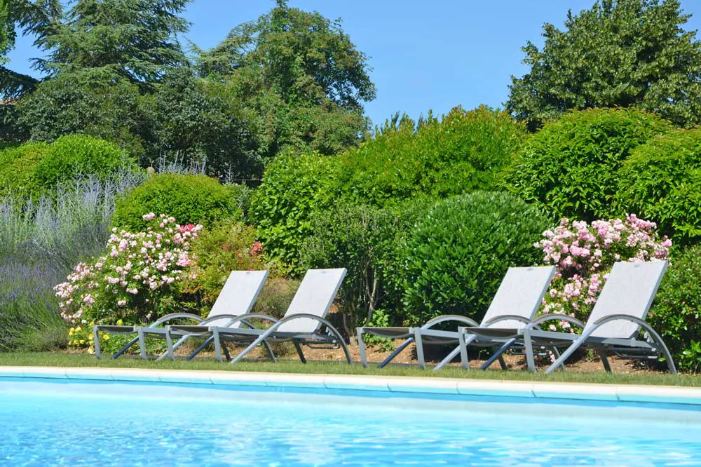 Photographie d'un jardin fleuri avec une piscine