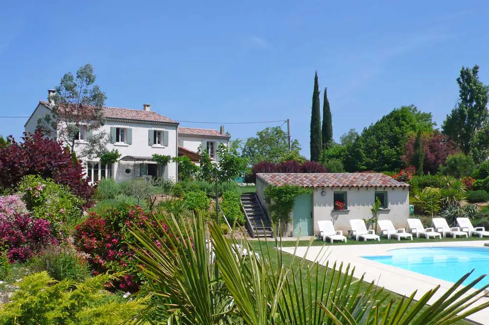 Photographie d'un piscine et d'un jardin avec un palmier